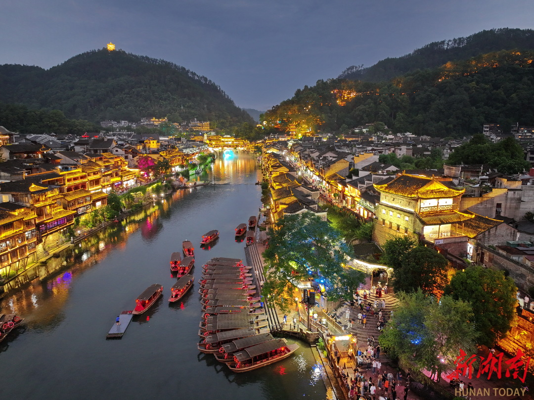 鳳凰古城流光溢彩，游人如織。