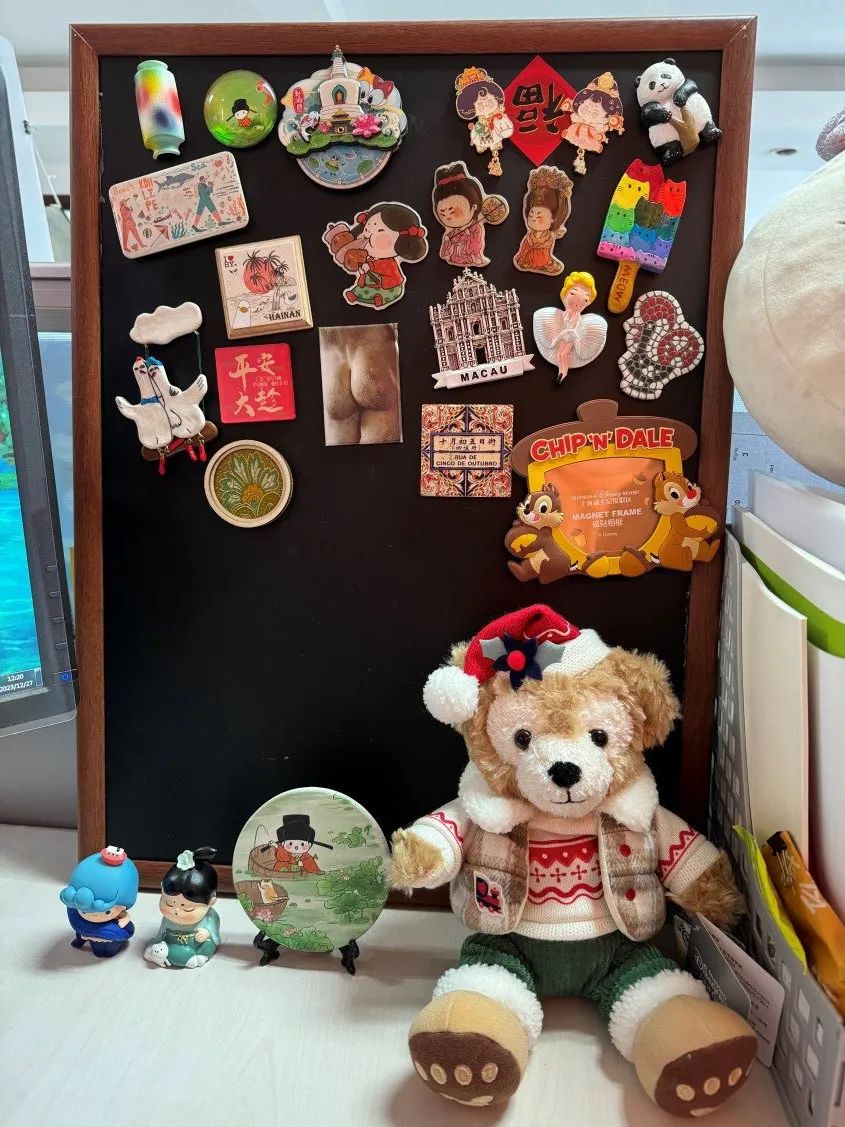 辦公桌一角的冰箱貼小黑板，是朋友和自己從各地帶回來的愛與新知