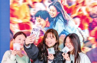 2月18日，觀眾在貴州省黔西市一家影院的電影海報前留影。 新華社發(fā)