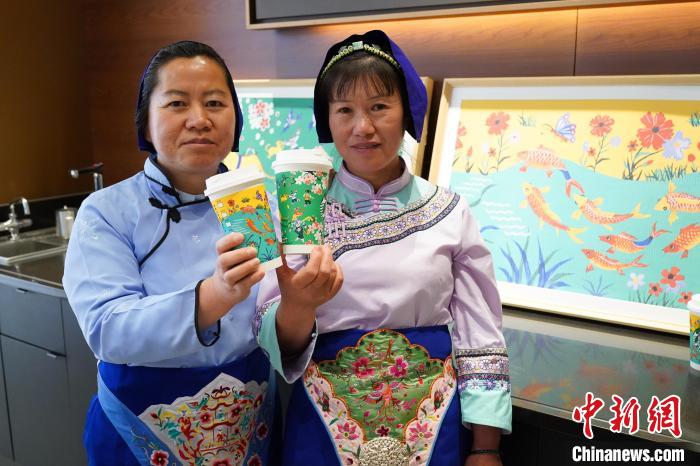 圖為農(nóng)民畫家展示她們被印在星巴克咖啡紙杯上的畫作。中新網(wǎng)記者劉冉陽 攝