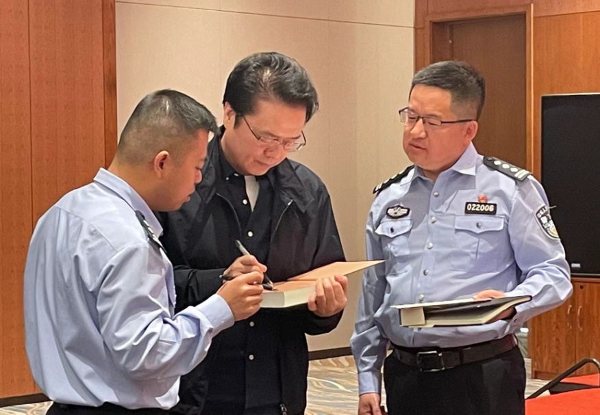 活動(dòng)期間，陳彥（圖中）在給警營作家簽名。