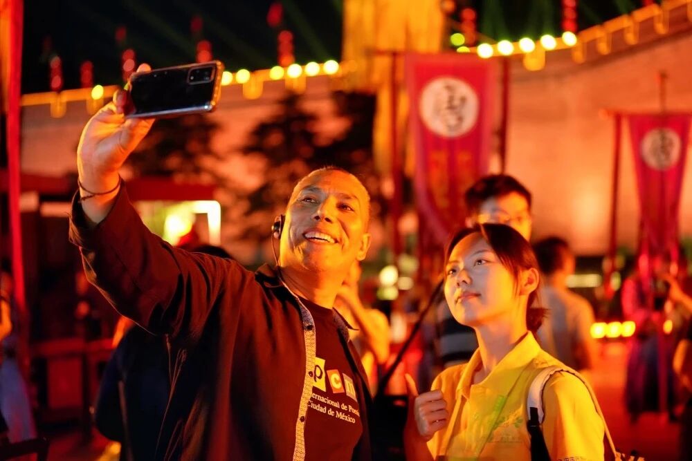 參加2025國際青春詩會的拉美詩人和中國詩人在西安永寧門觀看歡迎儀式。圖為墨西哥詩人馬努艾爾·夸烏特勒在歡迎儀式后與志愿者合影