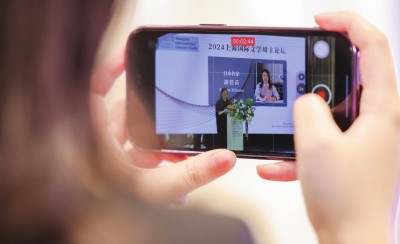 在2024上海國際文學(xué)周主論壇的會場，一位觀眾在用手機錄制日本推理小說家湊佳苗的發(fā)言。上海國際文學(xué)周供圖